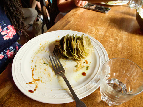 Plate With Leftover Artichokes After a Meal at a Restaurant