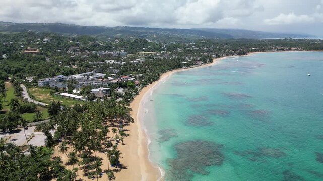 4K drone shot of Punta Popy Beach &mdash; sandy coastline and turquoise sea in bright daylight. Perfect for airline ads