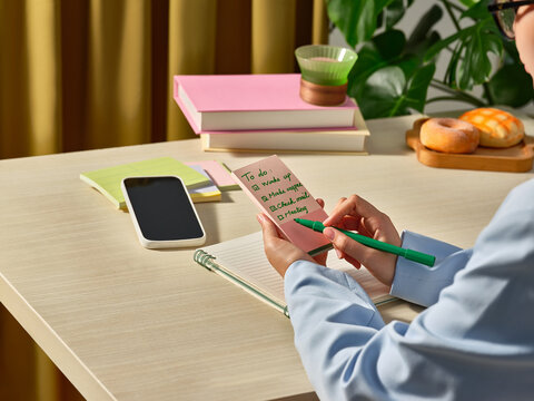 A woman carefully checks off items on her to-do list while working