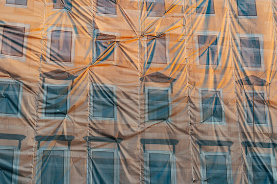 Building restoration in progress revealed through construction cover