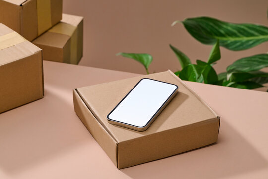 Smartphone mockup on a cardboard box, perfect for showcasing apps