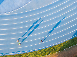 Aerial View Runners Blue Track Long Shadows Golden Hour