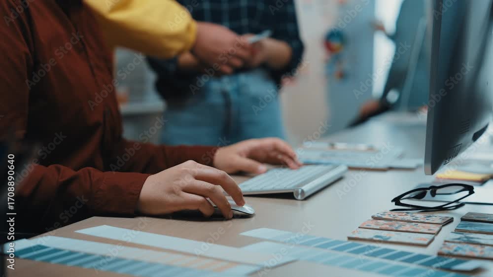 Poster a designer selects color palettes in a collaborative workspace while colleagues engage in creative d