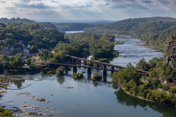 The Shenandoah and Potomac rivers converge at historic Harpers Ferry in this breathtaking high-angle shot, capturing the iconic town and railroad bridge nestled in the Appalachian mountains.