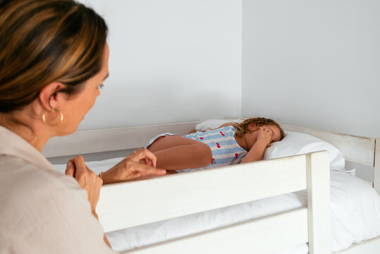 Mother waking up her daughter for school in the morning