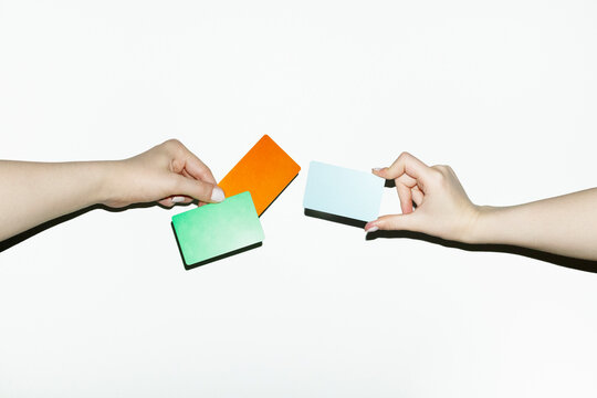 Conceptual symbolic photo of money transfer: two hand holding cards