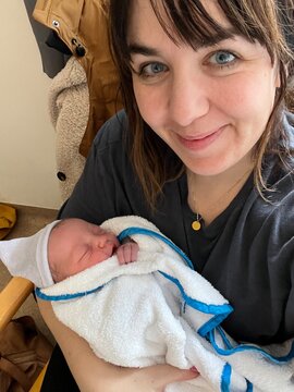 mother snuggling baby wrapped in towel