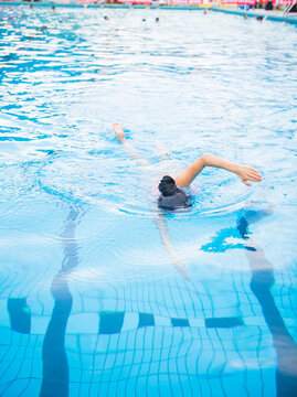 Female Swimmer Freestyle in Outdoor Pool with Blue Water