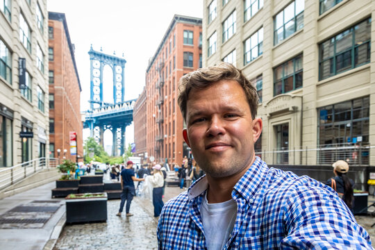 Manhattan Bridge view framed by red brick buildings in DUMBO Brooklyn
