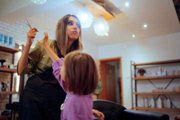 Naughty Child at the Hair Salon trying to Grab Scissors. Bad behaving little client putting herself...