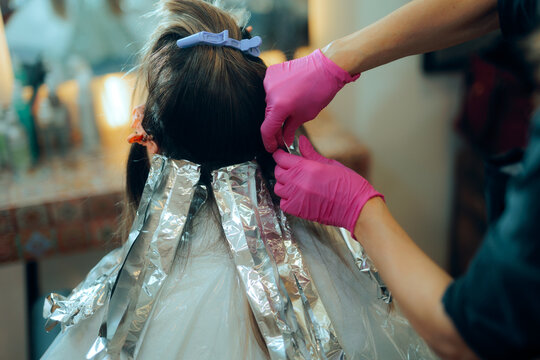  Hairdresser Doing a Balayage Technique with aluminum foil. Woman getting highlights at the hair salon changing her look