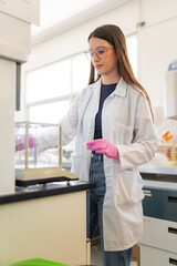 Female scientist using analytical balance in laboratory