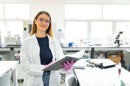 Female scientist writing notes in laboratory