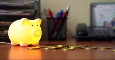 Piggy bank lamp with coins on a desk, office setting