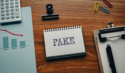 There is notebook with the word FAKE. It is as an eye-catching image.