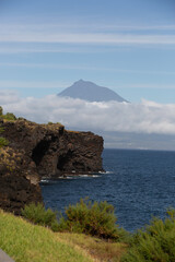 Faial, Azores, island, Portugal, Mountain is in the background of a beautiful blue ocean. The sky is clear and the sun is shining