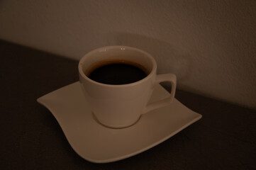 Close-up of espresso cup on table with dark lighting