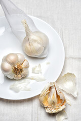Garlic Bulb still life. Garlic on a white plate and kitchen towel.