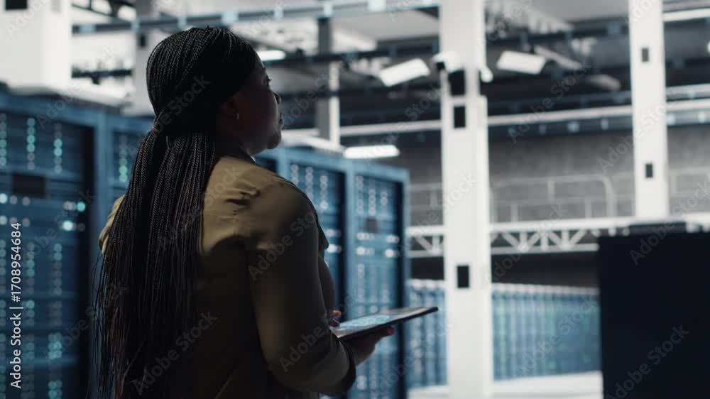 Poster woman walking through data center server rows, implementing advanced cooling and power management so