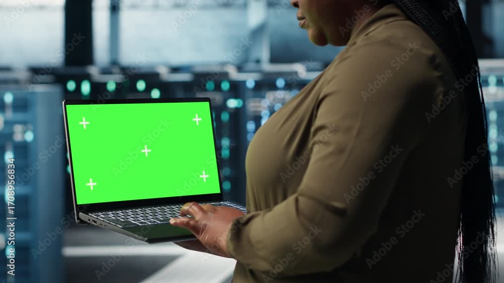 Poster programmer in data center using app on isolated screen laptop to ensure error free mainframes networ