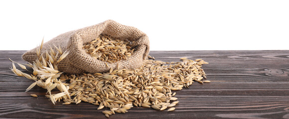Oat grains, spikelets and burlap bag on wooden table against white background