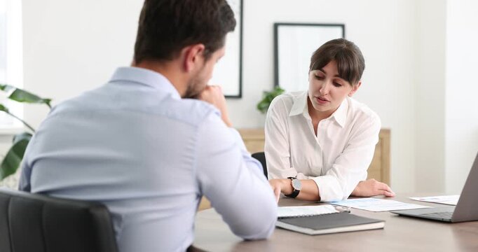 Consultant working with client at table in office. Business meeting