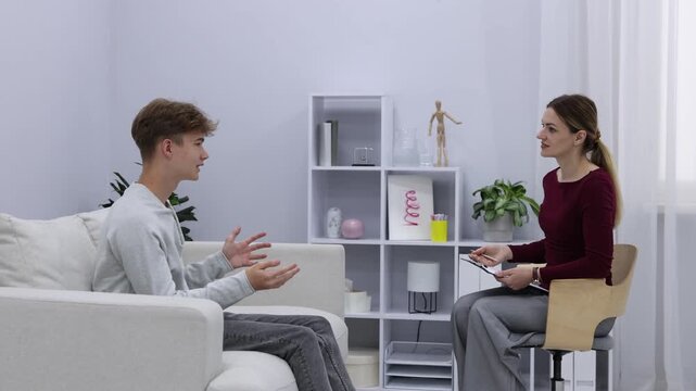 Professional psychologist working with teenage boy in office