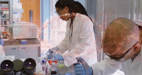 Pouring Black woman in lab coat transferring orange solution at laboratory bench, with flask