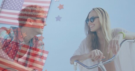 Smiling friends wearing sunglasses leaning on bike handlebars at boardwalk, with US flag overlay