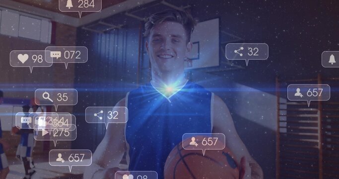Smiling man wearing blue jersey holding orange basketball on gym court, with digital notifications