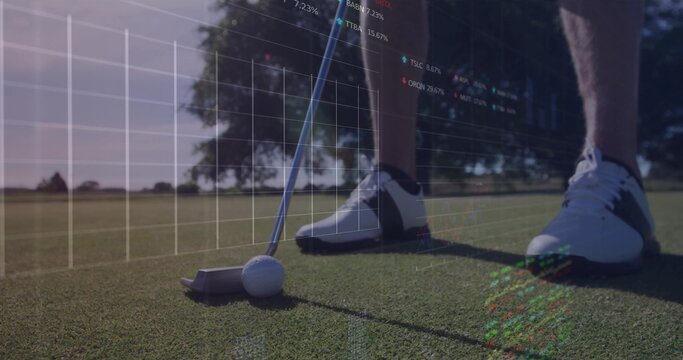 Adult golfer wearing spiked shoes using putter striking ball on putting green, with finance charts