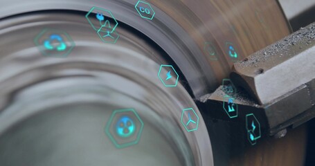 Cutting carbide insert engaging spinning metal cylinder on shop floor, showing teal digital icons