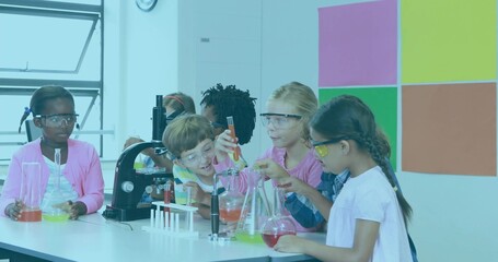 Children wearing goggles handling colorful liquids in flasks and test tubes in science classroom