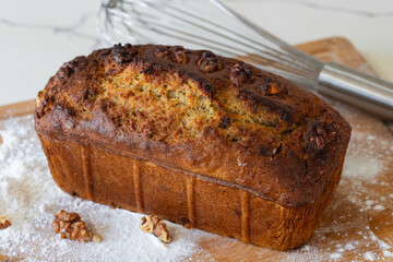 Homemade banana bread with walnuts on wooden board
