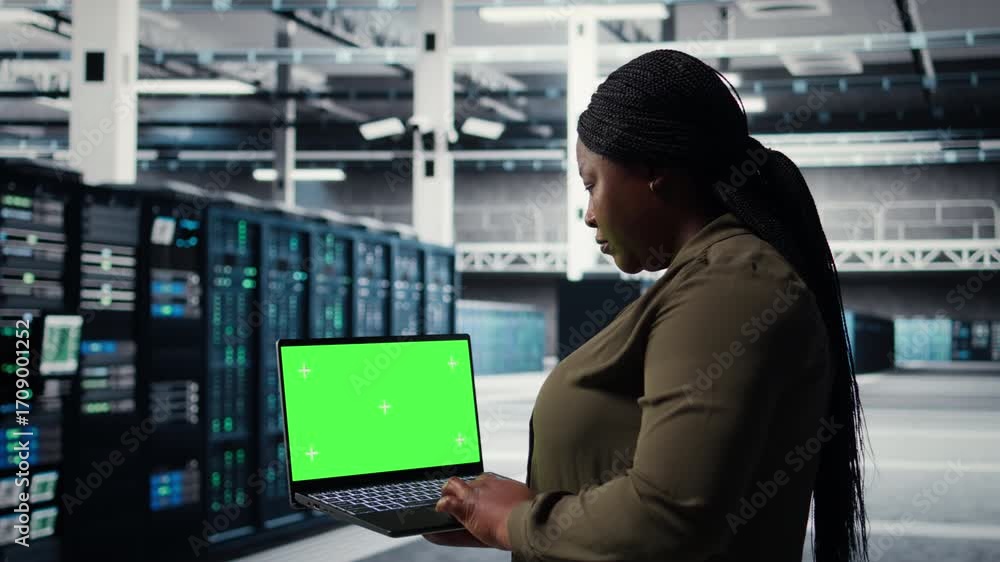 Poster server room admin uses green screen laptop to upgrade mainframes for increase in workload capacity. 