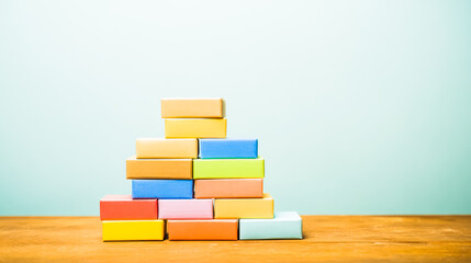 Colorful package boxes neatly stacked on a wooden table, showcasing modern packaging design.
