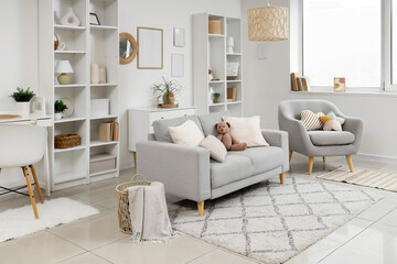 Stylish interior of living room with soft sofa and shelving unit
