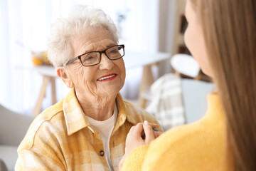 Happy senior woman and her granddaughter at home