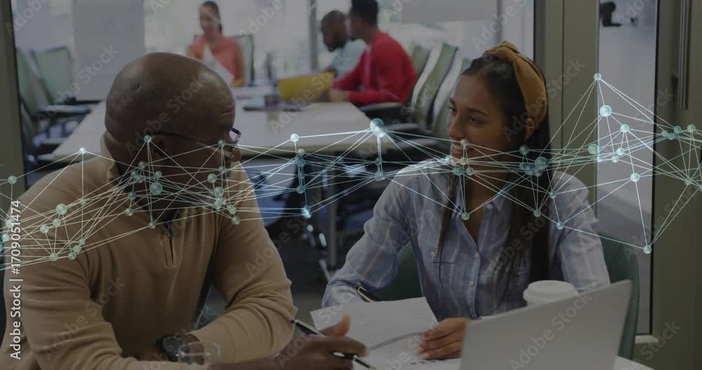 Poster advisor pointing document triggers network overlay while intern jotting notes for business review