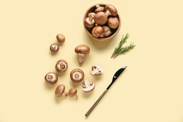 Bowl with fresh raw mushrooms and rosemary on yellow background