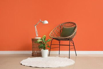 Interior of stylish living room with chair, houseplant and lamp on coffee table