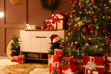 Interior of living room with commode, Christmas trees and presents