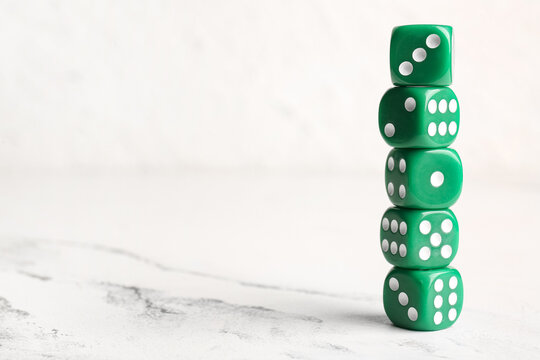 Stack of green dices on light background