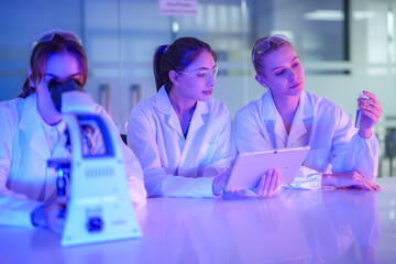 A team of female researchers collaborates on a biotechnology project. They are analyzing assay...