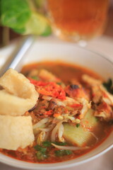 Bowl of Authentic Soto Ayam with Shredded Chicken and Aromatic Spices