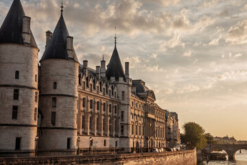 La Conciergerie on the Quai de l'Horloge at sunset, with turrets and stone facade along the Seine in Paris, France. The historic courthouse, former prison is a major attraction on Ile de la Cité. © Jerome