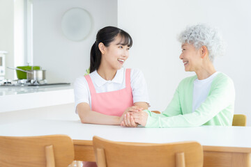 Fototapeta premium 高齢者を介護する若い女性介護士