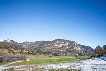 Panorama of Stara Fuzina village in the Bohinj Valley beneath the Julian Alps in Slovenia, showing meadows, rooftops, and a winding path. Stara fuzina is a slovenian village in the Julian alps