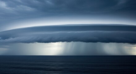 Fototapeta premium A long, ominous shelf cloud stretches across the horizon over the ocean, with sheets of rain falling. A dramatic meteorological event.