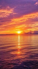 Naklejka premium Bright Sun Glimmering on Sea with Purple Clouds, Gold Sky, Water Reflection